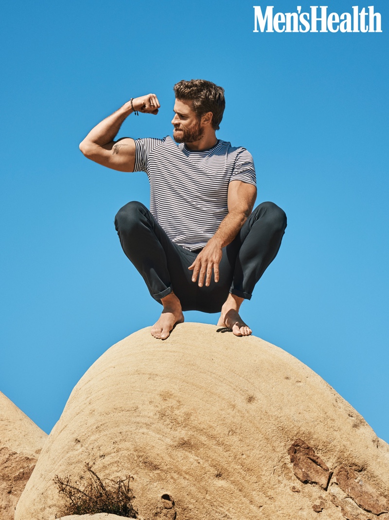 Flexing his bicep for Men's Health, Liam Hemsworth wears a COS t-shirt with Outerknown pants.