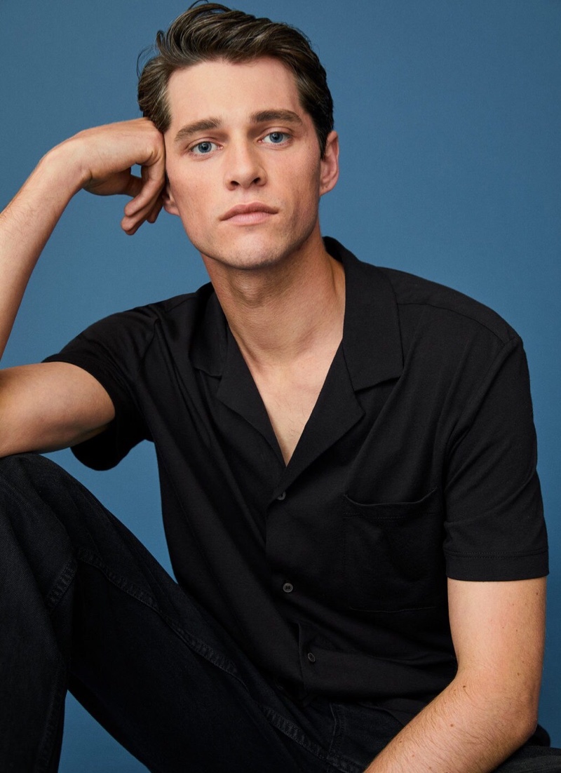 Embracing effortless style, Luke Powell sports a black Cuban-collared shirt and jeans from Mango.