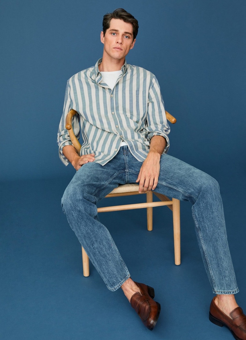 Luke Powell models a striped cotton shirt with regular fit jeans from Mango.
