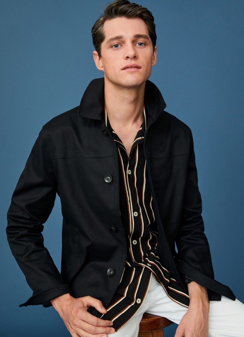Model Luke Powell wears a striped shirt with a cotton buttoned jacket and white jeans by Mango.