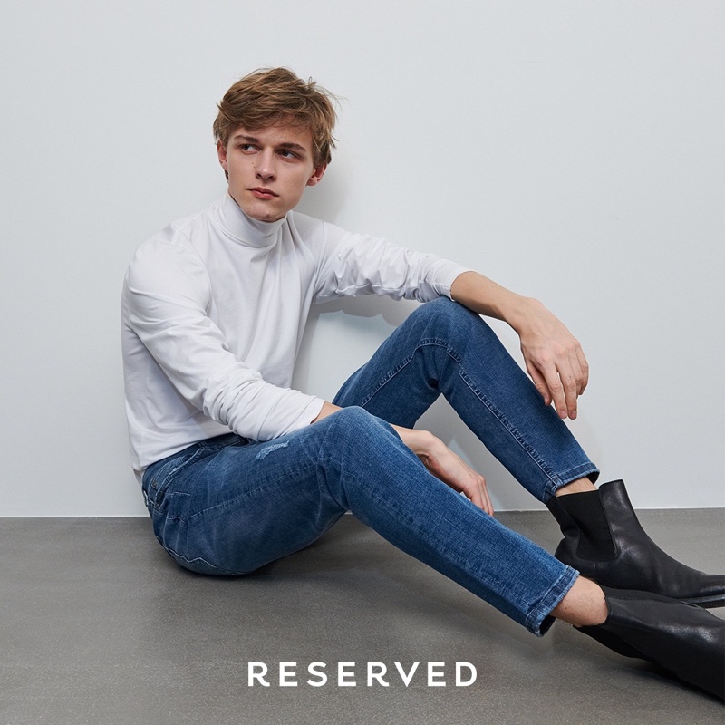 Max Barczak sports a white turtleneck with slim-fit jeans and black leather boots from Reserved.