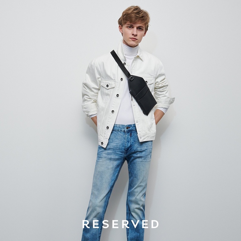 Mixing denim, Max Barczak wears a white trucker jacket and blue rinse jeans from Reserved.