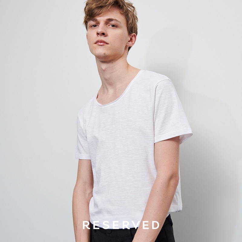 Photographed in a slouchy white tee, Max Barczak connects with Reserved for spring.