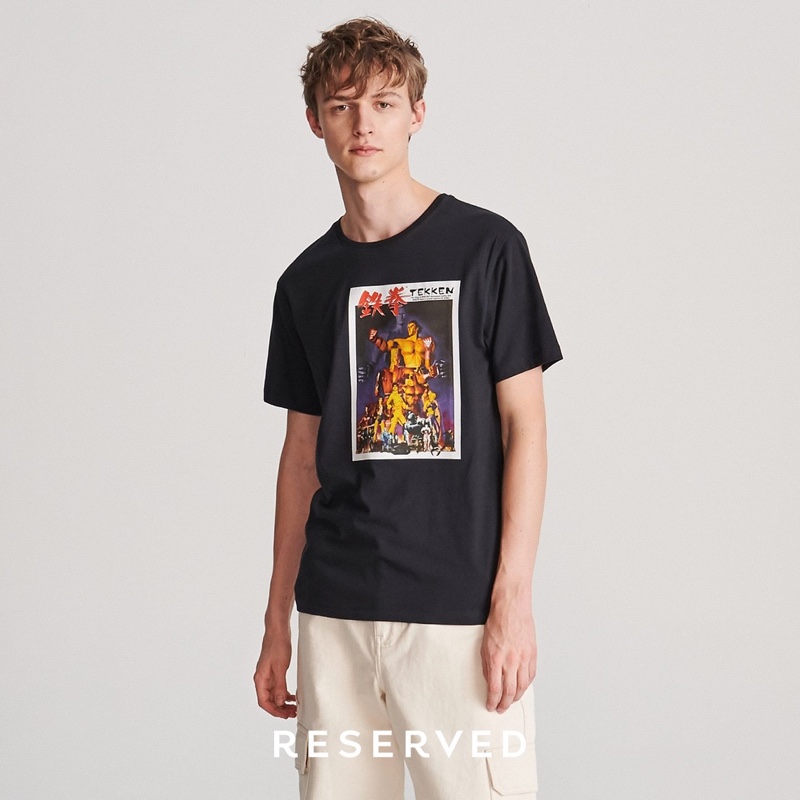 Embracing everyday casual wear, Max Barczak models a graphic t-shirt with cargo pants.