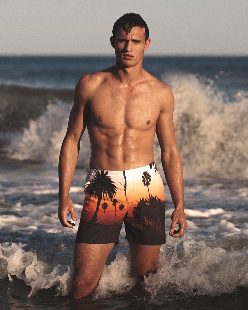 Julian Schneyder fronts Orlebar Brown's spring-summer 2020 campaign in a pair of the brand's Bulldog sunset silhouette mid-length swim shorts.