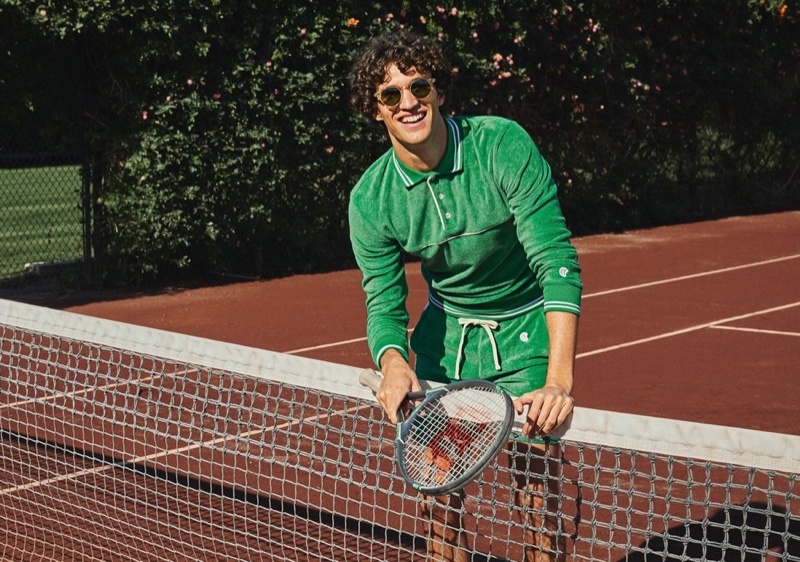 All smiles, Francisco Henriques wears a Todd Snyder + Champion terry long-sleeve polo and side stripe shorts in turf green.