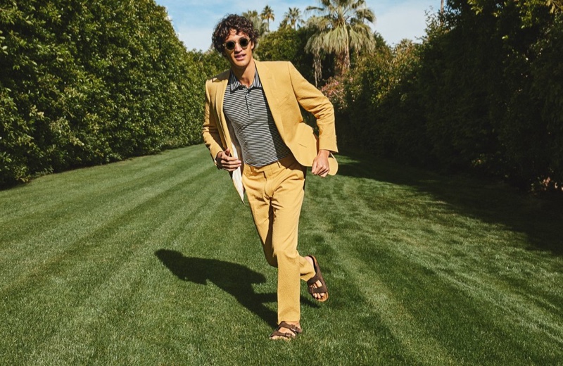 Making a colorful statement, Francisco Henriques sports a Todd Snyder Sutton seersucker suit jacket and trousers in mustard. A striped polo shirt and Birkenstock Arizona sandals complete his look.