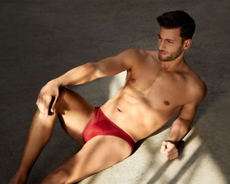 Lounging, Kevin Sampaio wears a red swimsuit from 2(x)ist.