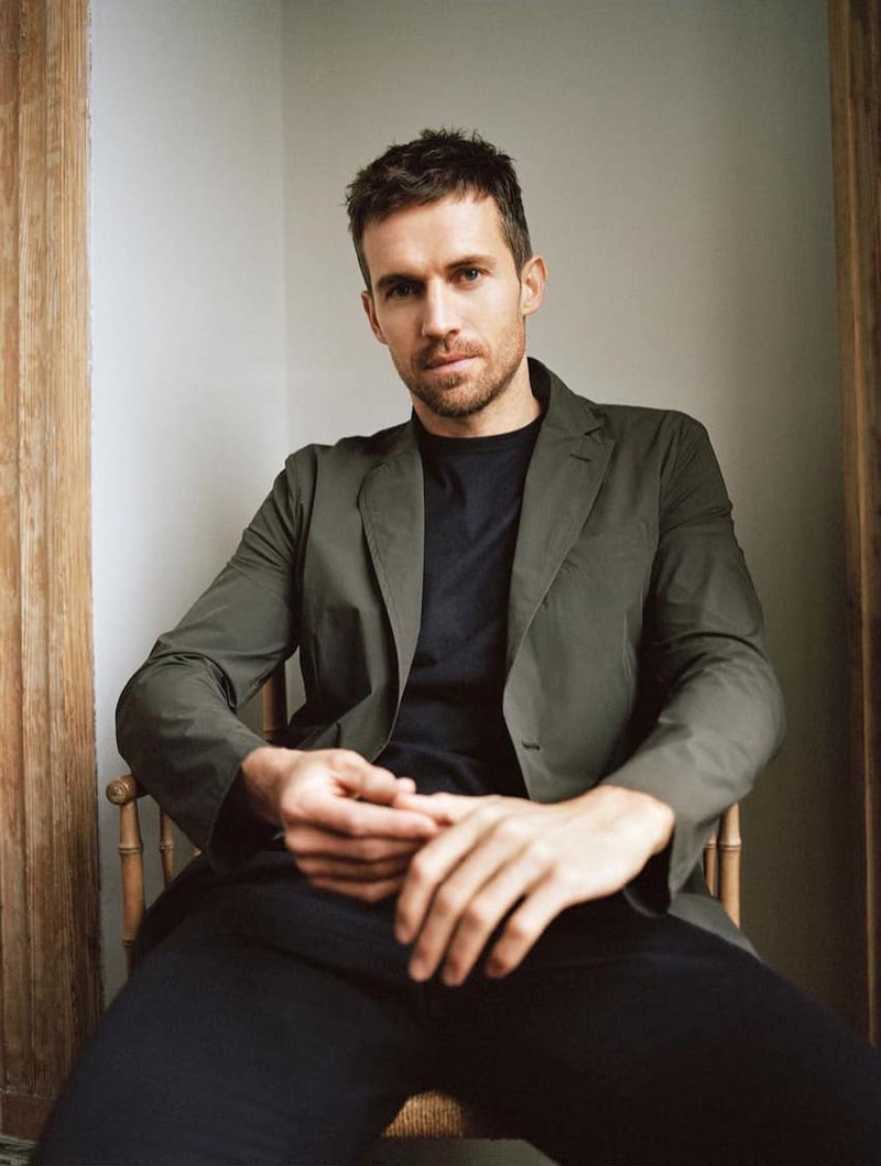 Sitting for a portrait, Andrew Cooper dons a Massimo Dutti blazer, t-shirt, and linen trousers.