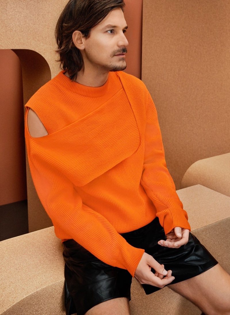 Embracing a pop of color in an orange cashmere sweater, Jarrod Scott also wears leather shorts from Bottega Veneta.