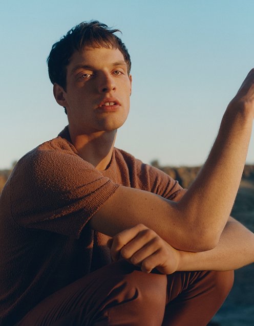 Connecting with Club Monaco, Rocky Harwood models a textured short-sleeve sweater with elasticated pants.