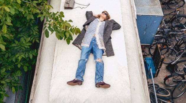 Florian Witte rests on top of a metal building for Gucci's fall 2020 campaign.