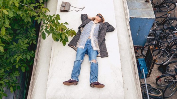 Florian Witte rests on top of a metal building for Gucci's fall 2020 campaign.