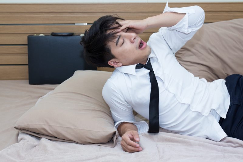 Man in Bed Wearing Shirt and Tie