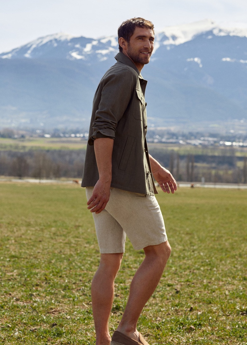 Stepping outdoors, Will Chalker models a linen-cotton blend overshirt and chino Bermuda shorts from Mango's Committed line.