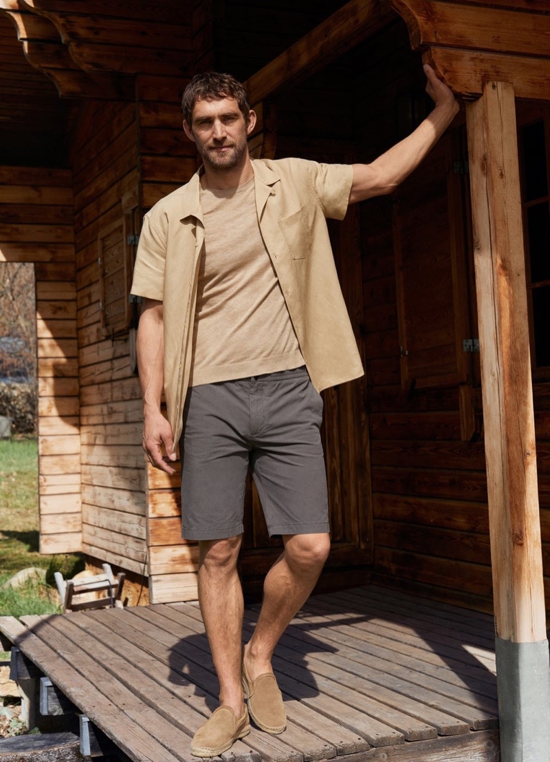 British model Will Chalker dons a Mango linen-blend short-sleeve shirt with elastic waist cotton Bermuda shorts.