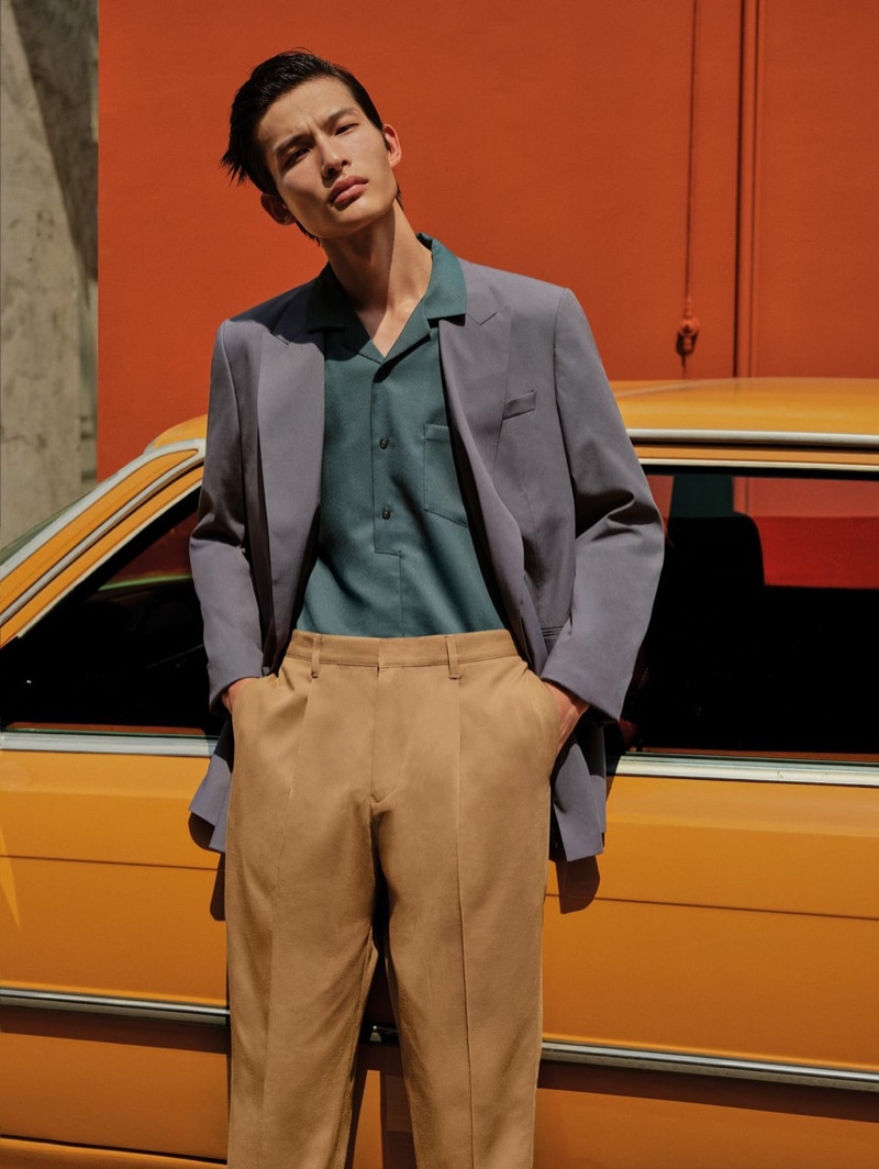 Model Huang Shixin wears a double-breasted suit jacket, textured polo shirt, and cropped pleated chino pants from Zara.