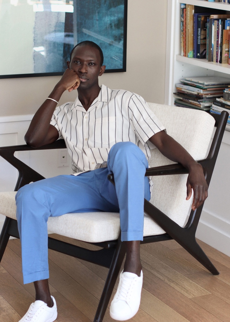 Reuniting with Mango for summer, Armando Cabral models a striped shirt with pleated trousers.