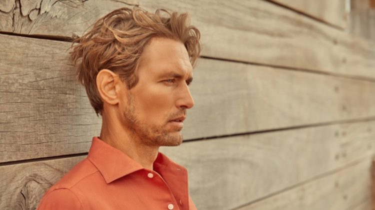 Delivering a side profile, Robertas Aukstuolis dons a coral Portofino linen shirt for Luca Faloni's high summer 2020 campaign.