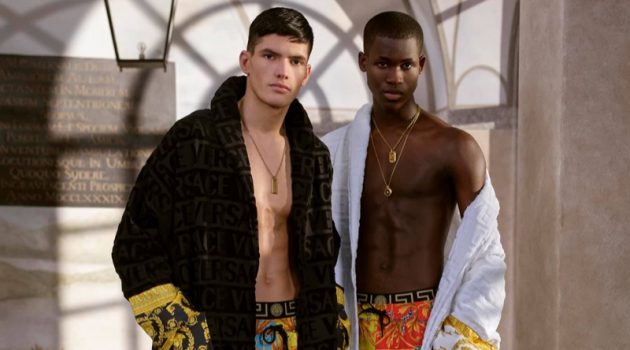 Models Islam Dulatov and Ismael Savane sport custom robes with swimwear from Versace's summer capsule collection.