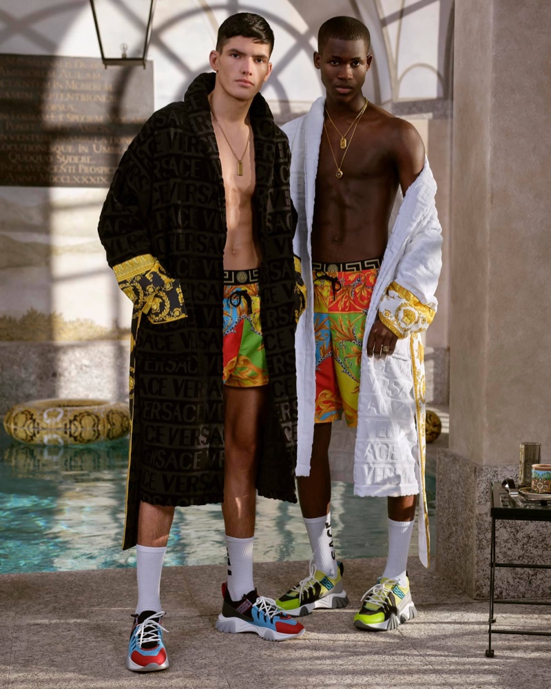 Models Islam Dulatov and Ismael Savane sport custom robes with swimwear from Versace's summer capsule collection.