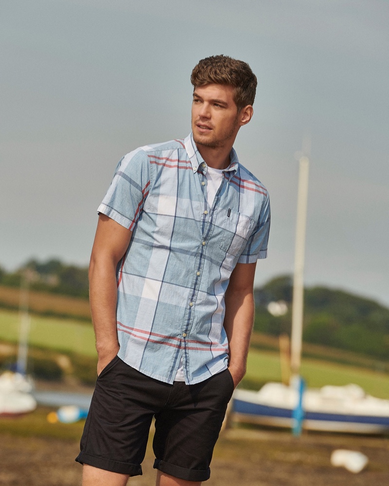 Front and center, Bertold Zahoran models a tartan short-sleeve shirt with cuffed shorts by Barbour.