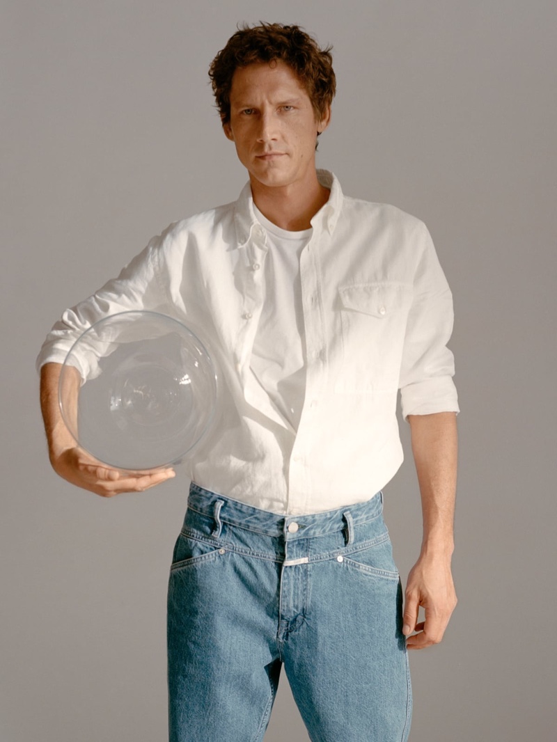 Roch Barbot models a white button-down shirt with jeans for Closed's fall 2020 campaign.