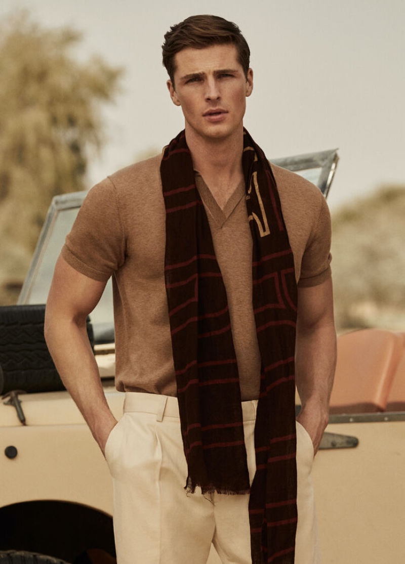 Edward Wilding models a short-sleeve tricot polo shirt with Pima cotton chinos and a printed logo scarf from Pedro del Hierro.