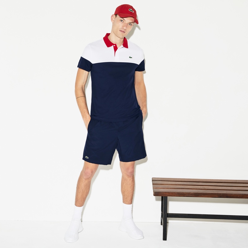 William Los embraces classic Lacoste style in the brand's sport tennis shorts.