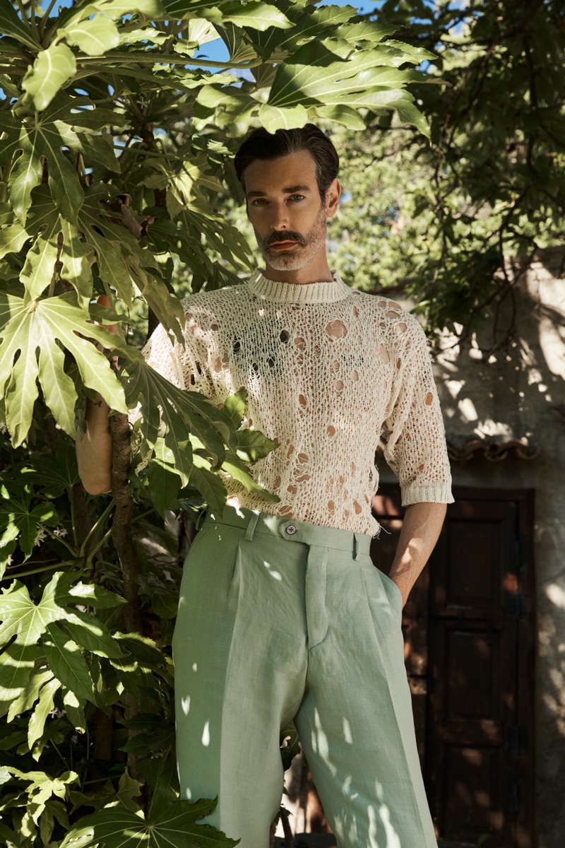 Richard Biedul dons a short-sleeve deconstructed sweater with pleated trousers from Luca Larenza's spring-summer 2021 collection.
