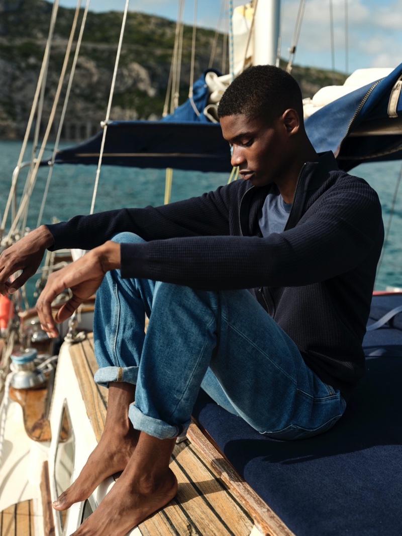 Enjoying a quiet moment, Rachide Embalo models a cashmere cardigan with a linen t-shirt and stone wash jeans from Massimo Dutti.