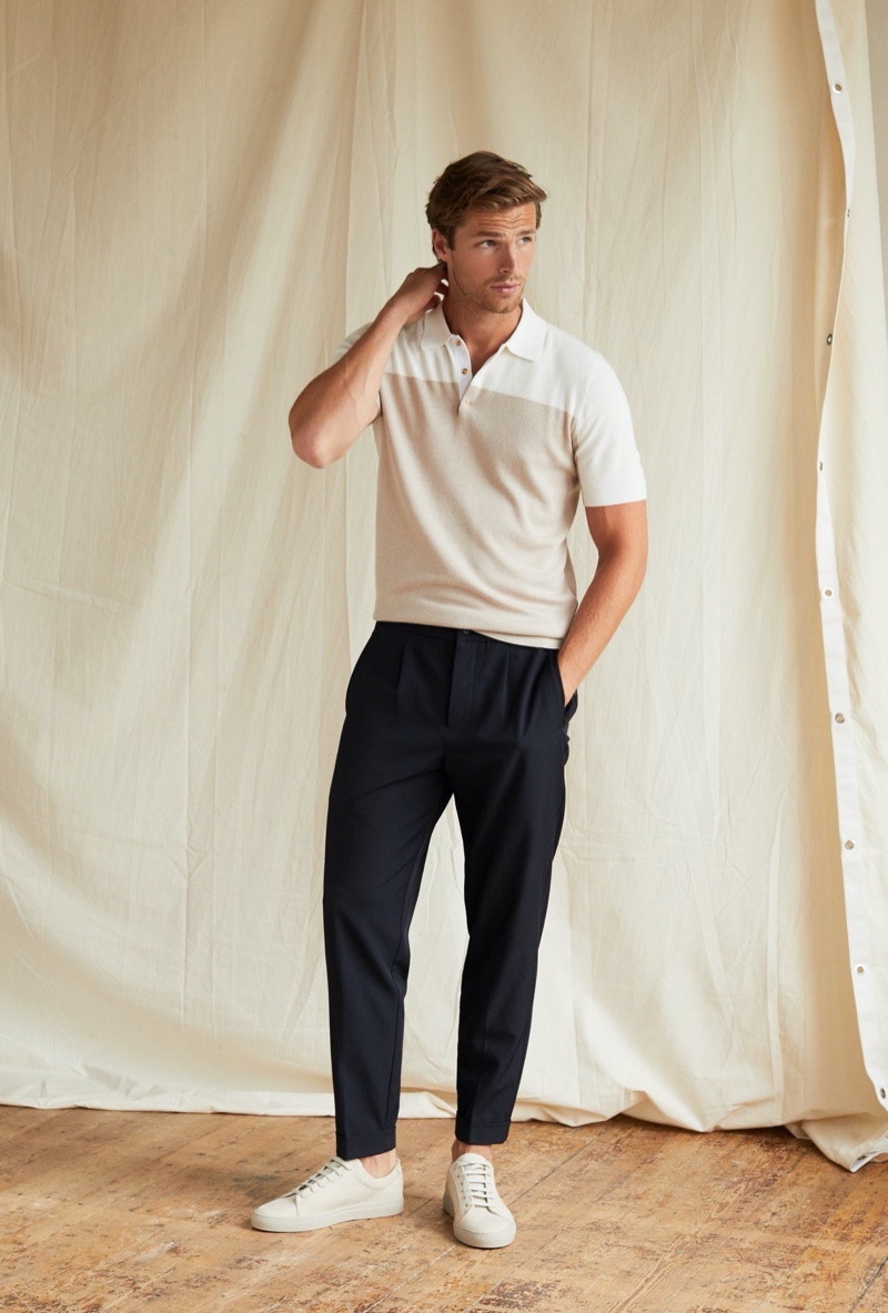 Front and center, Edward Wilding wears a color-block polo shirt with Reiss pleat front trousers in navy.