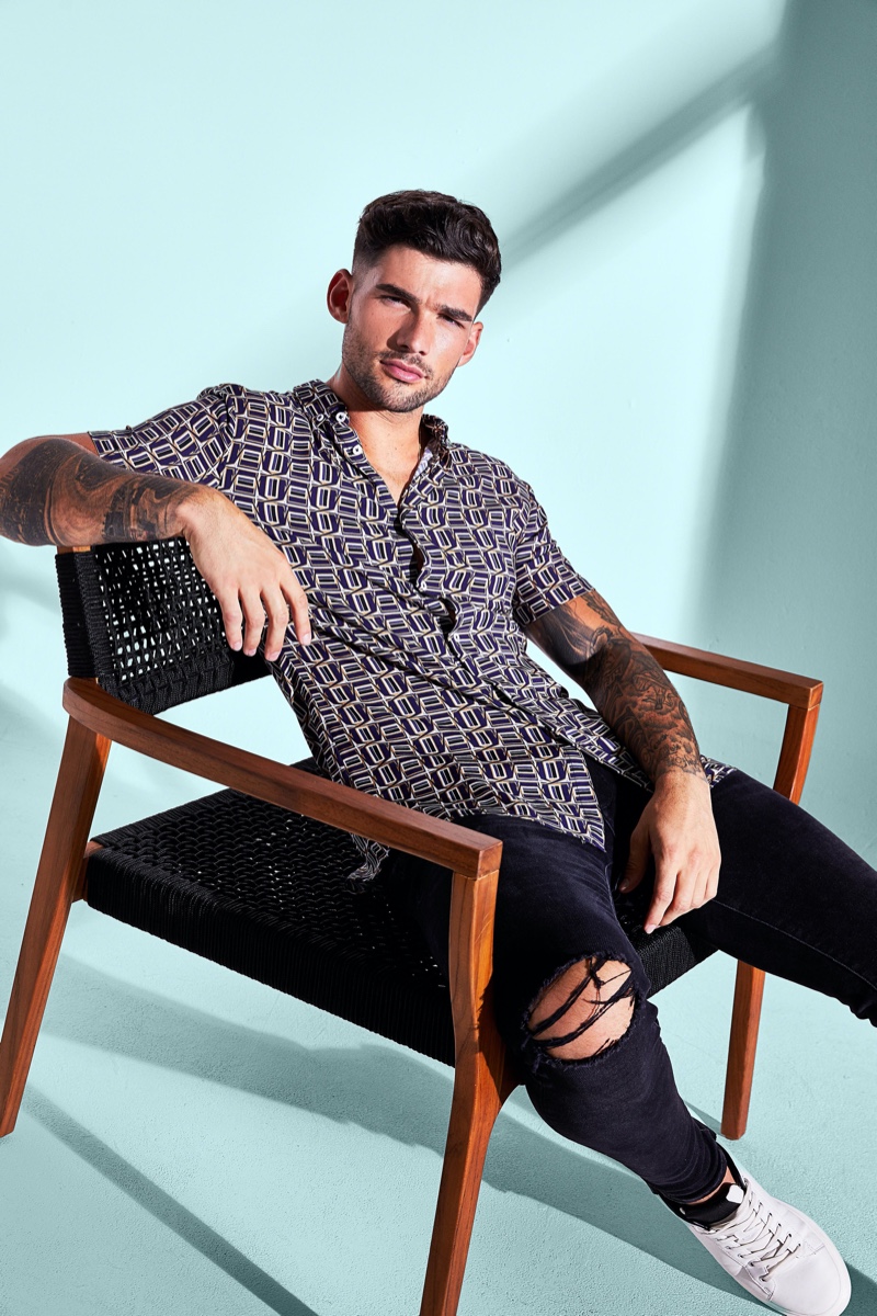 Brandan Stevens sports a short-sleeve printed shirt with ripped jeans from River Island.