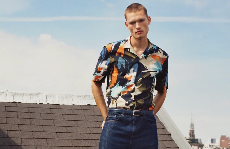 William Tackles Summer Style with Zara Taking to a rooftop in Amsterdam, William Los sports a graphic print short-sleeve shirt with classic blue denim jeans by Zara.