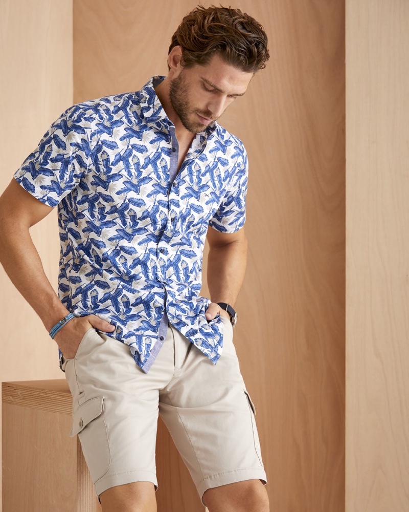 Model Simone Bredariol sports a printed short-sleeve shirt with cargo shorts from BRAX's summer 2020 collection.