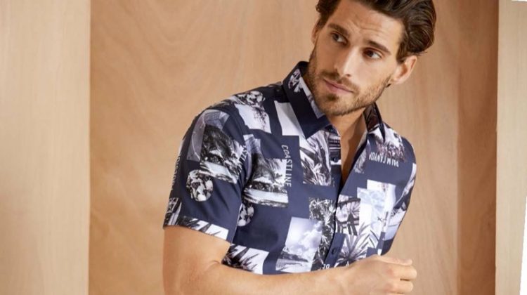 Simone Bredariol dons a "High Summer" short-sleeve shirt with denim shorts from BRAX's summer 2020 collection.