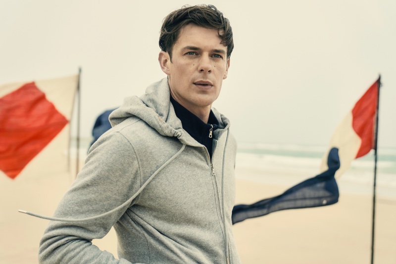 Lewis Jamison models an Orlebar Brown mid grey hooded zip-thru sweatshirt.