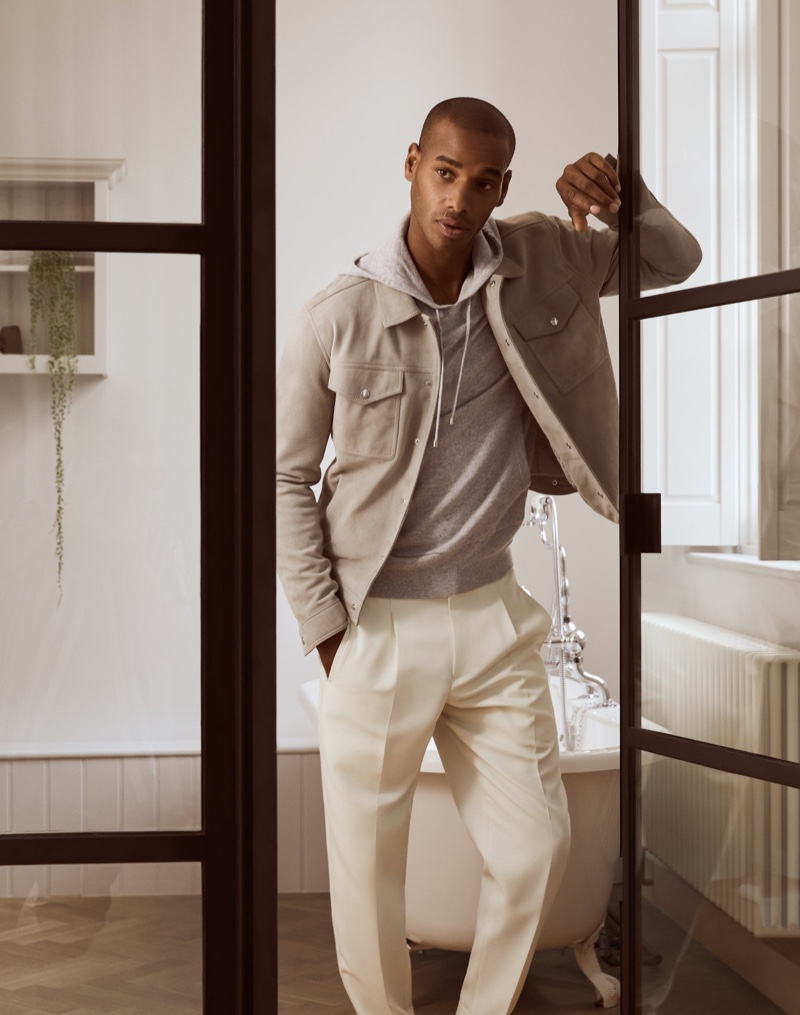 Embracing a wardrobe of neutrals, Sacha M'Baye wears a Jagger jacket with a Santiago hoodie and Monk trousers from Reiss.