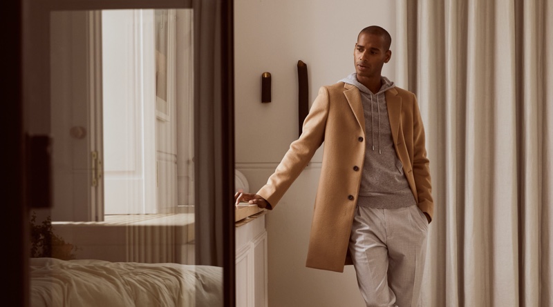 Sacha M'Baye dons a Reiss Gable coat with the brand's Santiago hoodie and Brighton trousers.