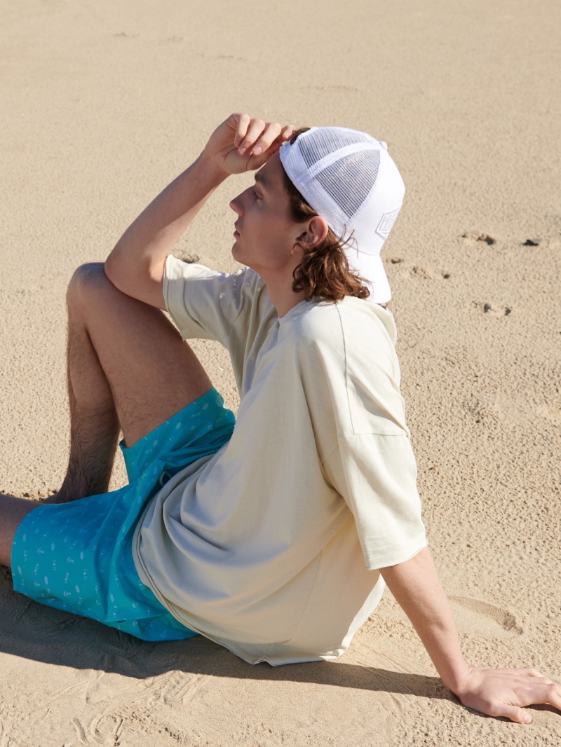 Relaxing at the beach, Pawel Feledyn sports a summer look from Reserved.