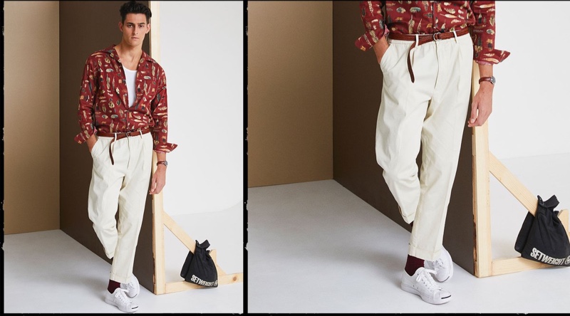 Front and center, Rhys Pickering models Todd Snyder's Liberty camp collar long-sleeve shirt in feather print with The Pleated Pant in ivory coast.