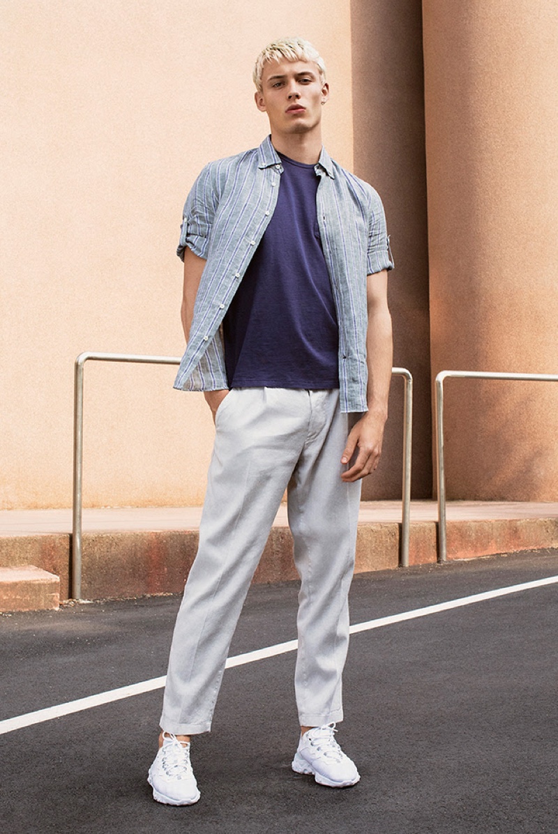 Front and center, João Knorr wears a striped shirt with a relaxed tee and pants from YOOX.