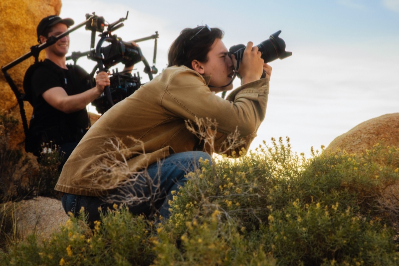 Captured behind the scenes, Cole Sprouse works on photographing the Jimmy Choo x Timberland campaign.