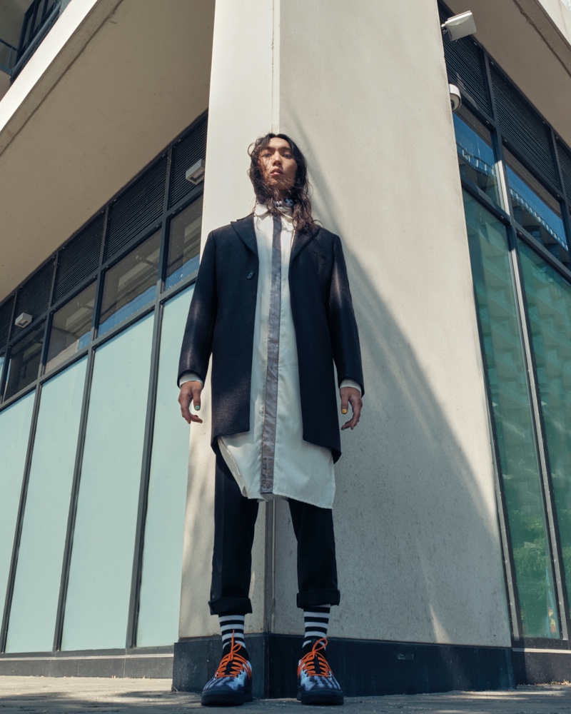 Sooleen wears velvet trimmed overcoat Christopher Bates, longline dress shirt House of Dwir, pants Rhowan James, socks H&M, and sneakers Puma.