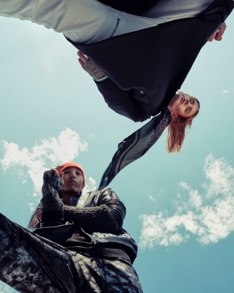 Fashionisto Exclusive: Sooleen Park and Jayden photographed by David J. Fulde. Left: Sooleen wears orange beanie Leone Napoli, bomber jacket Hip and Bone, tank, knit sweater, and pants House of Dwir. Right: Jayden wears hand warmers Aldo, pants and scarf H&M, sweater and trench Christopher Bates.