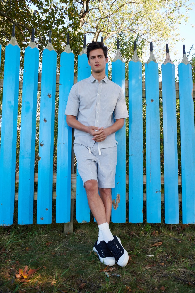 Posing against a bright blue fence, Garrett Neff wears a coordinated seersucker look by ATM.