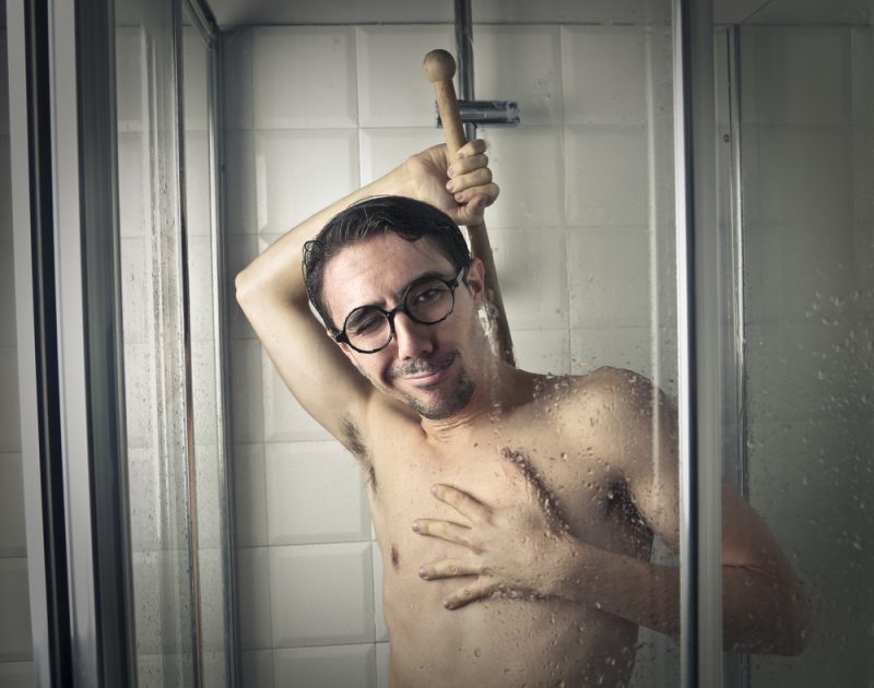 Man Using Cleaning Brush in Shower