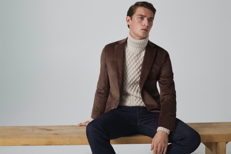 Otto Lotz dons a slim-fit dyed wool blazer with a cable-knit turtleneck sweater and jeans from Massimo Dutti.