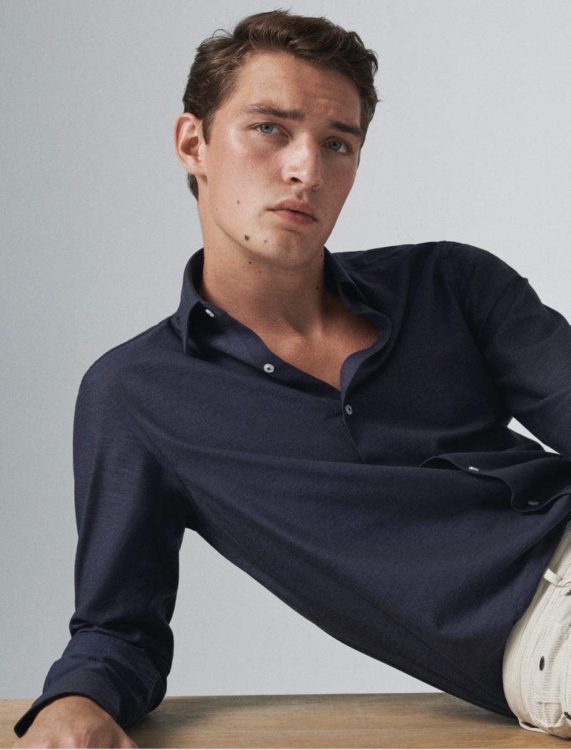 Model Otto Lotz dons a Massimo Dutti slim-fit cotton twill shirt with slim-fit denim-effect trousers.