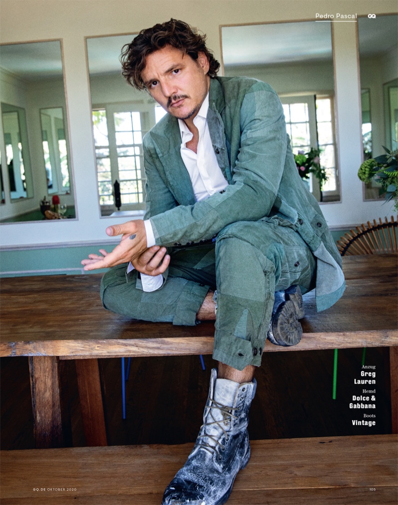 Appearing in a fashion shoot for GQ Germany, Pedro Pascal dons a patchwork suit by Greg Lauren. He also wears a Dolce & Gabbana shirt with vintage boots.